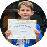 Elementary student holding a certificate at Waxahachie Prep Academy.